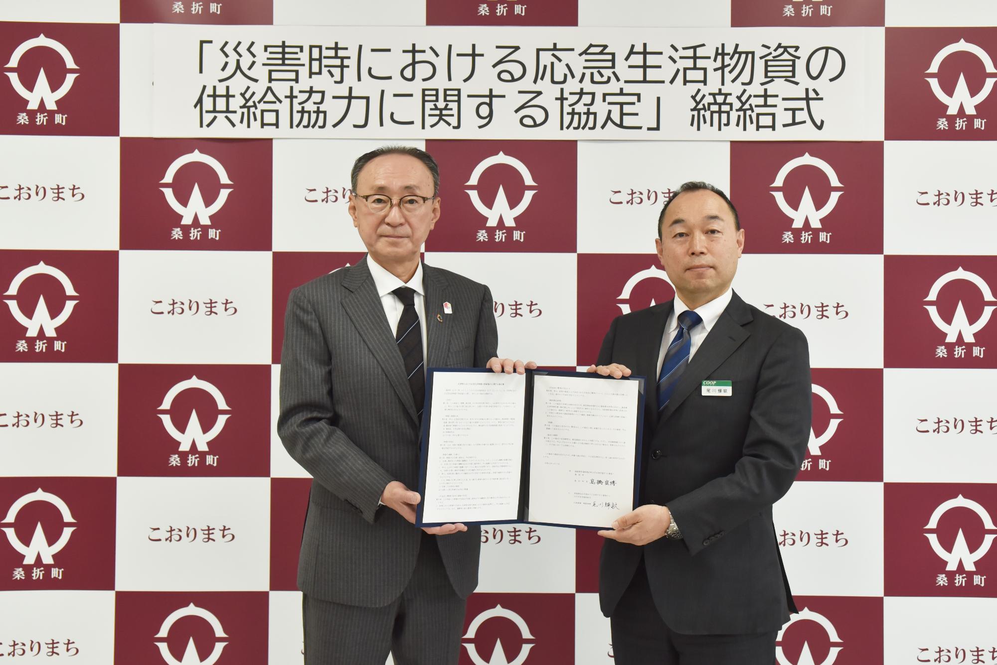 協定書を手にする（左から）高橋町長、みやぎ生活協同組合の尾川代表理事の写真